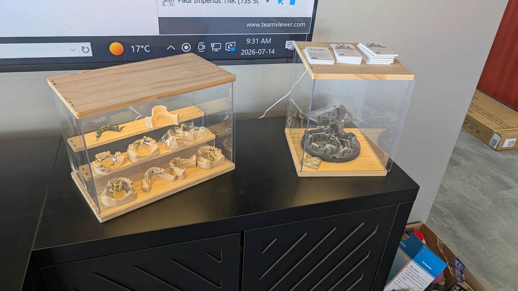 Finished dental frameworks displayed beside the CAD production monitor