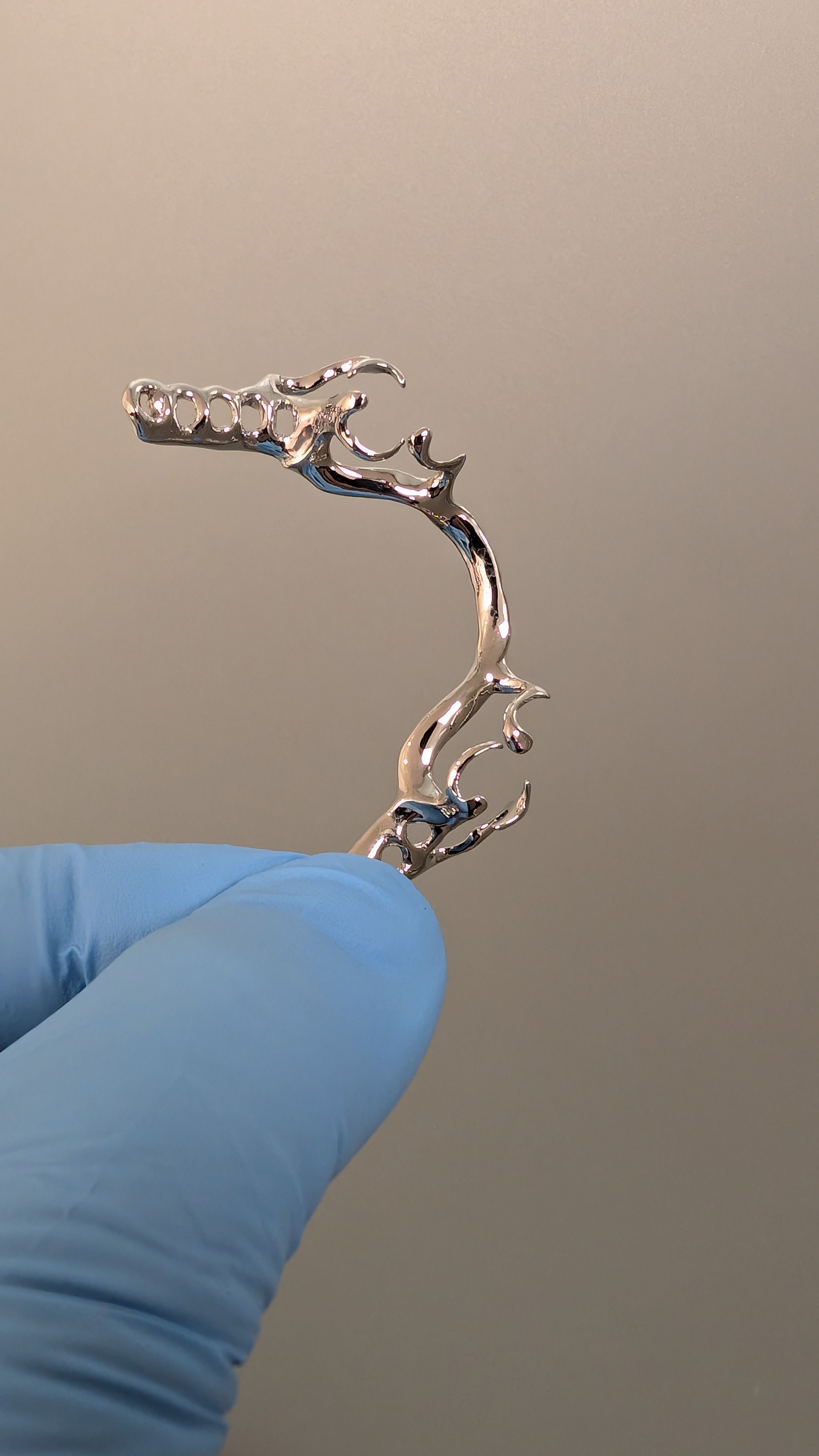 Polished chrome framework side profile held in blue glove